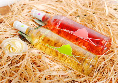 Divine Justine bottles with illustrated labels on straw packaging